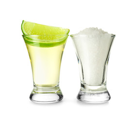 Shot of tequila, lime and salt on white background