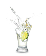 Dropping of lime into glass with tasty tequila on light background - obrazy, fototapety, plakaty