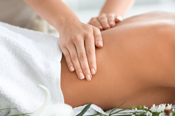Beautiful young woman receiving massage in spa salon, closeup