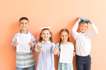 Happy children with answer sheets for school test on color background