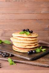 Tasty pancakes with berries on table