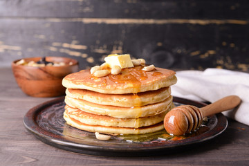 Tasty pancakes with honey and butter on table