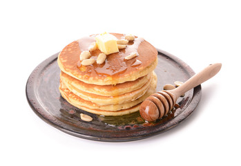 Tasty pancakes with butter and honey on white background