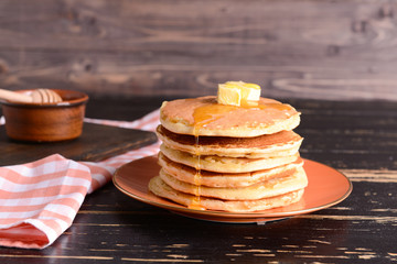 Tasty pancakes with butter on table