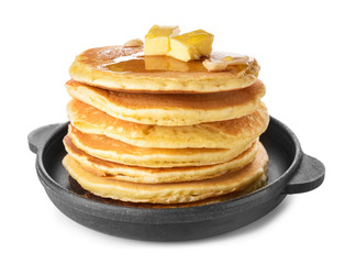 Tasty pancakes with butter in frying pan on white background