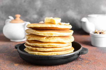 Frying pan with tasty pancakes on table