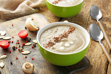 Bowl of tasty mushroom cream soup on wooden table