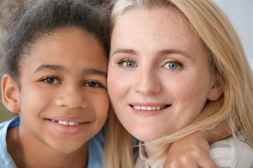 Happy woman with her African-American daughter at home