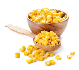 Bowl and spoon with corn kernels on white background