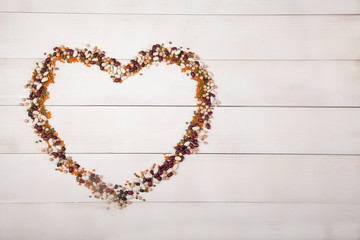 beans, lentils and beans laid out in the form of a heart on a white wooden background