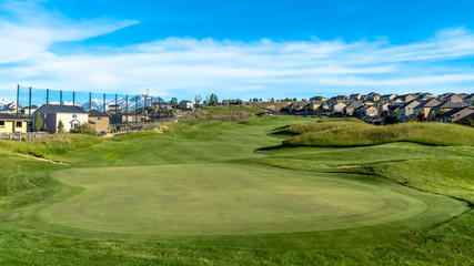 Obraz premium Panorama Golf course and homes under blue sky with clouds viewed on a sunny day