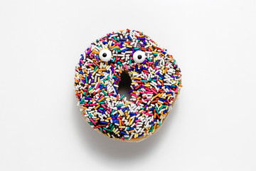 Funny shock face chocolate donut with sprinkles on a white background, creative minimal food concept with copy space