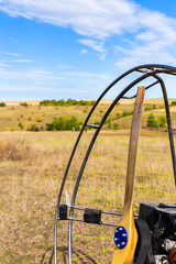Closeup of a propeller with a motor-paraglider motor against the background of a field.
