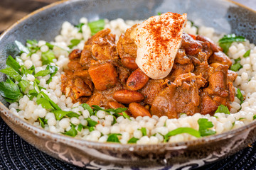 A traditional Moroccan dish called chicken Tajine featuring Saffron, Honey, Almonds, Dates, Couscous and Labneh