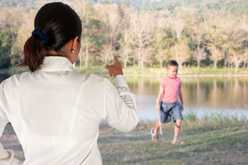 Mother scolds her child because of playing naughty and refusing to obey