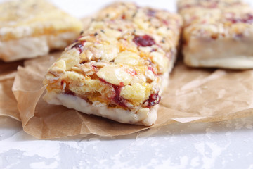 Granola bar on white table. Healthy organic sweet dessert snack. Cereal granola bar with nuts and dried fruits.