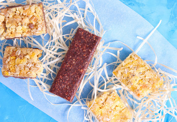 Granola bar on blue cement background. Healthy organic sweet dessert snack. Cereal granola bar with nuts and dried fruits.Top view.