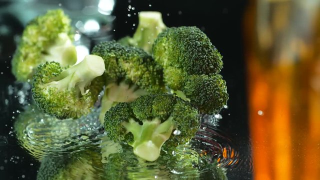 Beautiful broccoli falls on the background on the table