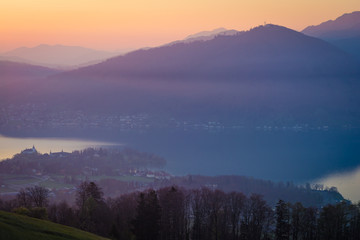 Naklejka na ściany i meble Sonnenaufgang mit Nebel über dem See in den Bergen - Traunsee