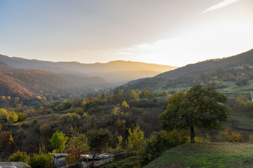 view of the mountain gorge in the light of the setting sun, shot during the season of golden autumn yellow-golden brown. A bright sunny day with light clouds in the sky.