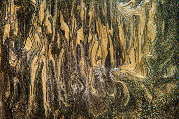 Unique handmade texture. Abstract decorative texture. Golden and black mixed paints on canvas.