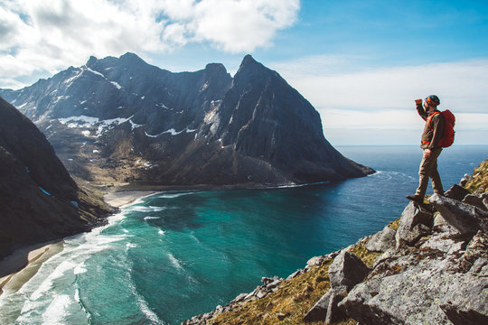 Man stand on cliff edge alone enjoying aerial view backpacking lifestyle travel adventure outdoor vacations