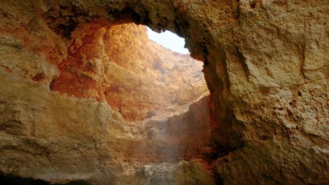 Impressive view of sunlight seeping through the amazing Benagil grotto into the sea in Lagoa, The Algarve, Portugal