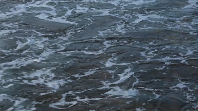 Video background of dark blue aqua sea water surface splashing outside. Real time full hd  footage.