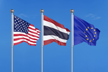 Three colored silky flags in the wind: USA (United States of America), EU (European Union) and Thailand. 3D illustration.