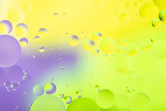 bright oily drops in water with colorful background, close-up © photollurg