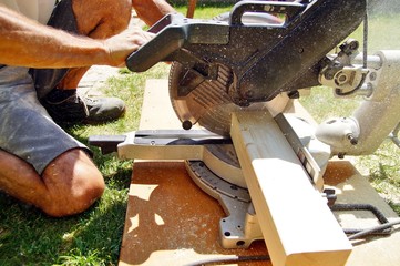 male worker hands sawing Natural Wooden beam using Circular Saw.  detail, carpenter hands at work with a saw. Construction Site Power Tools. Worker Cutting wood Using Circular Saw. Industrial Concept.