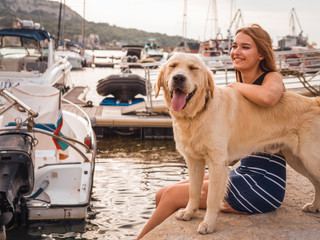 The girl in the marina walks with the dog. Labrador
