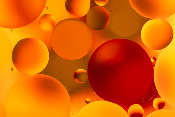 bright oily drops in water with colorful background, close-up 