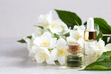 Fototapeta na wymiar Essential jasmine oil. Massage oil with jasmine flowers on a wooden background