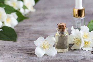 Essential jasmine oil. Massage oil with jasmine flowers on a wooden background
