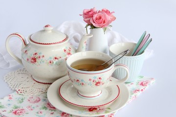 cup of tea with teapot and flowers on a background