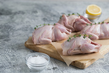 Raw uncooked quail. raw meat quails ready for cooking on a cutting board with copy space