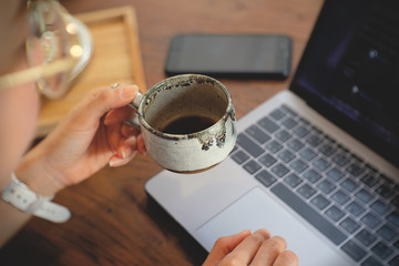 businessman using laptop and drinking coffee in cafe
