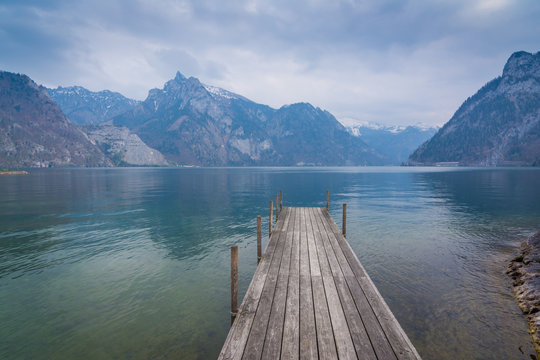 Steg am See in den Bergen unter Wolken Himmel