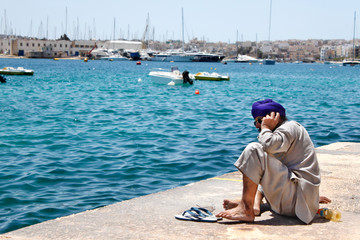 Fototapeta premium persona sentada junto al mar hablando por el movil.