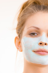 Girl apply green mud mask to face