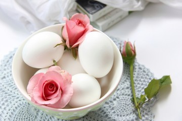 Pink rose and eggs in the bowl 