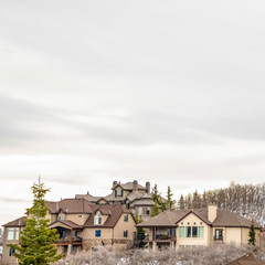Fototapeta na wymiar Square Luxurious multi storey homes on a snow covered mountain under overcast sky