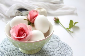 Pink rose and eggs in the bowl 