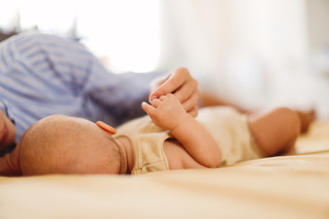 Caucasian Tender mother and baby are lying on bed
