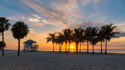 Sunrise at palm trees by the ocean beach in Key Biscayne, Florida