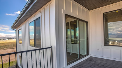 Fototapeta premium Panorama Home balcony with wooden floor metal railing and sliding glass access door