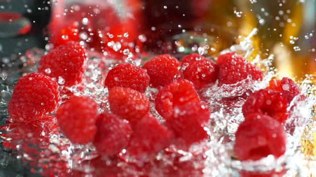 Juicy sweet red raspberries slowly falling on the table