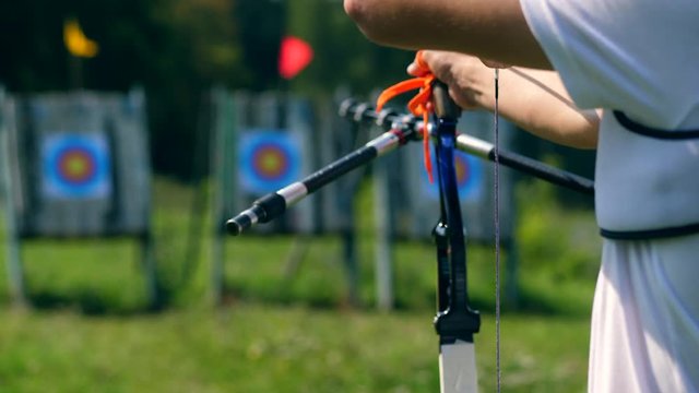The bow in male hands while preparing and aiming. Shooting with a bow and arrows.