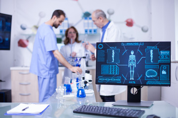 Team of researchers working and shwoing information on monitor display